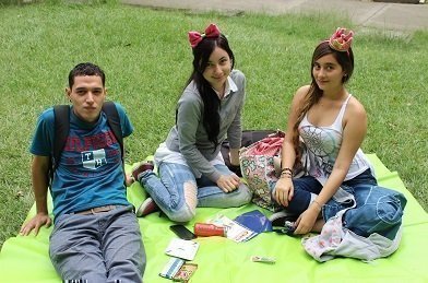 Estudiantes compartiendo juntos en un picnic en las zonas verdes de la Universidad