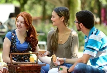 estudiantes compartiendo un picnic en las zonas verdes de la universidad